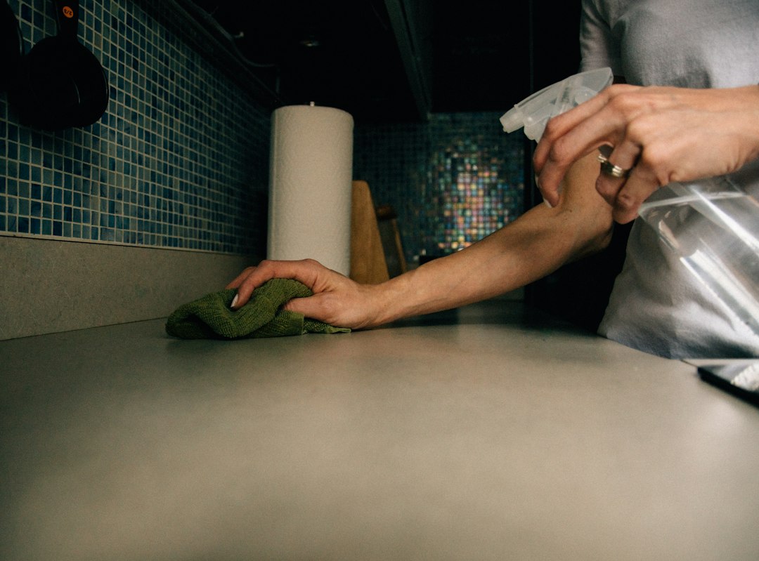 Hands cleaning a kitchen during final property preparation